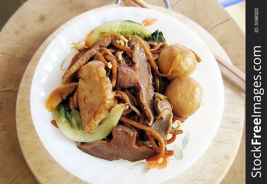 A bowl of fried mee with fish ball, fish paste, mushroom, vegetables. asian food