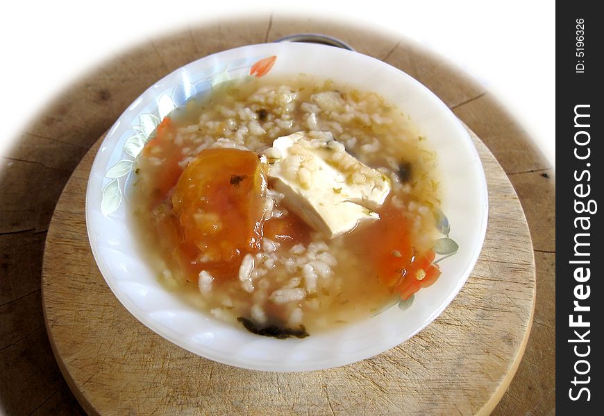 A bowl of porridge eith bean curd, tomato, seaweed,