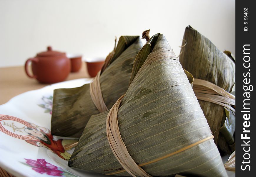 A pyramid-shaped mass of glutinous rice wrapped in leaves, one culture occasion in Chinese