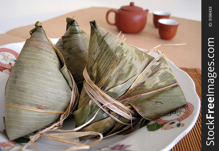 A pyramid-shaped mass of glutinous rice wrapped in leaves, one culture occasion in Chinese