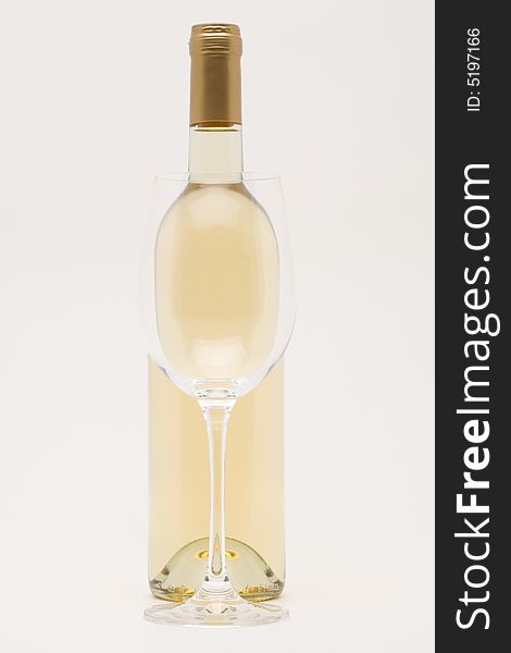 Isolated white wine bottle with empty glass in front