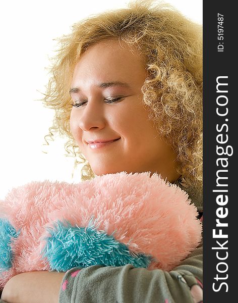 Young woman with closed eyes embracing a pillow. Young woman with closed eyes embracing a pillow