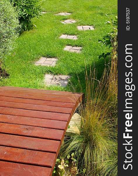 Garden stone path with grass growing up between the stones