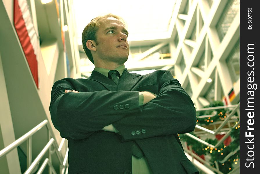 Confident businessman standing with his arms folded in an office building