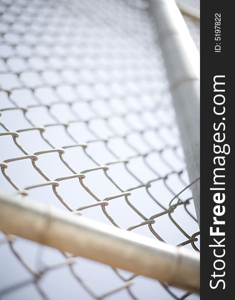 Close-up of a fence with two major beams in front of the chain linked fence