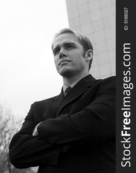 Young businessman wearing suit standing outside office building. Young businessman wearing suit standing outside office building