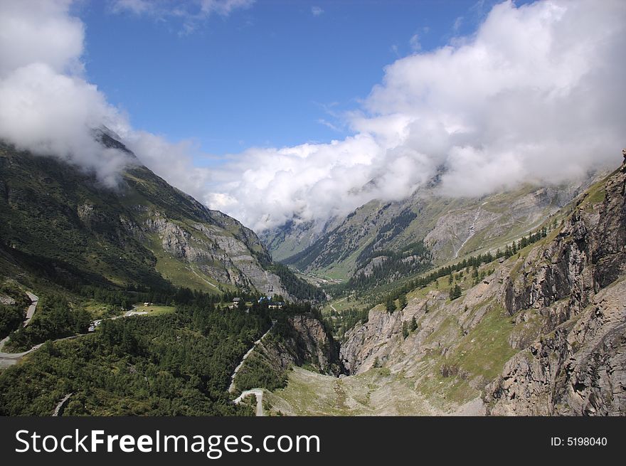 Swiss mountain landscape, clouds and green rocky slopes, Alps, Switzerland.