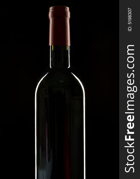 Wine bottle on a black background with rim light. Wine bottle on a black background with rim light