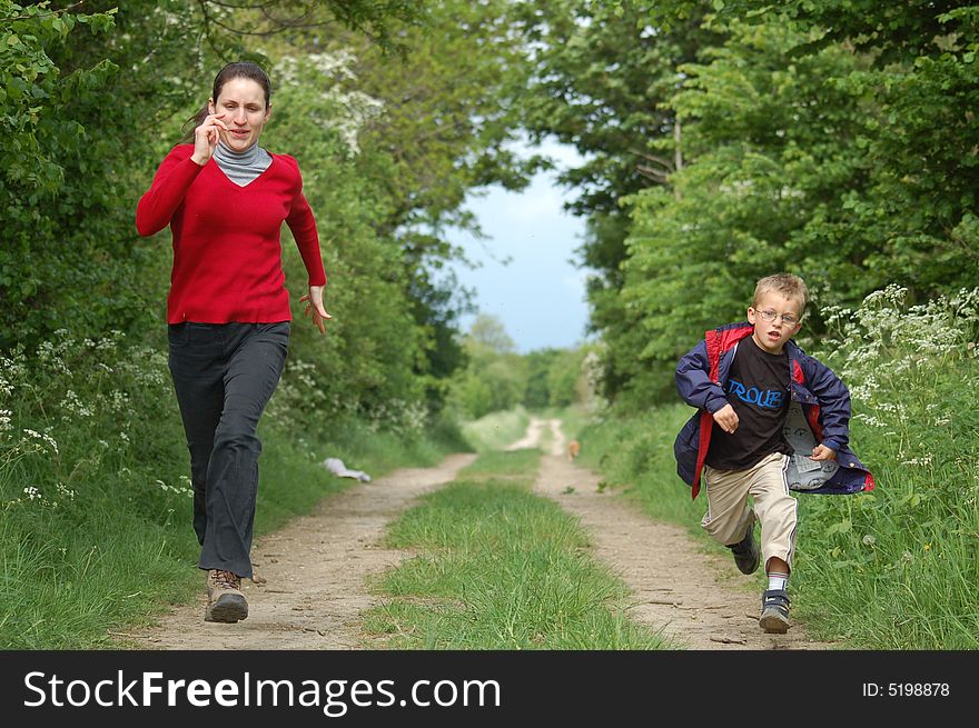 A mother and son having a race along a country path. A mother and son having a race along a country path