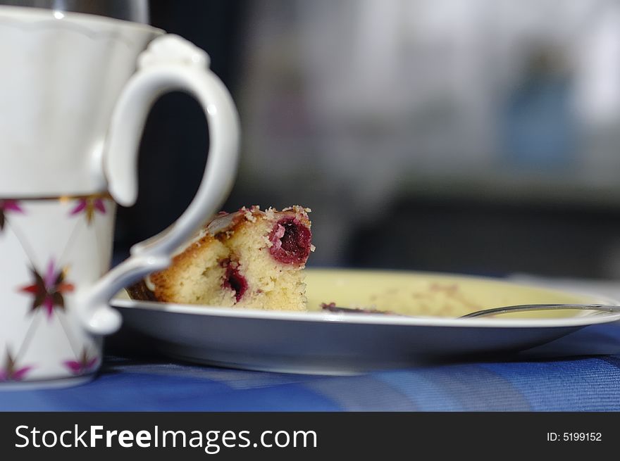 Photo of tea cup and piece of cake on plate