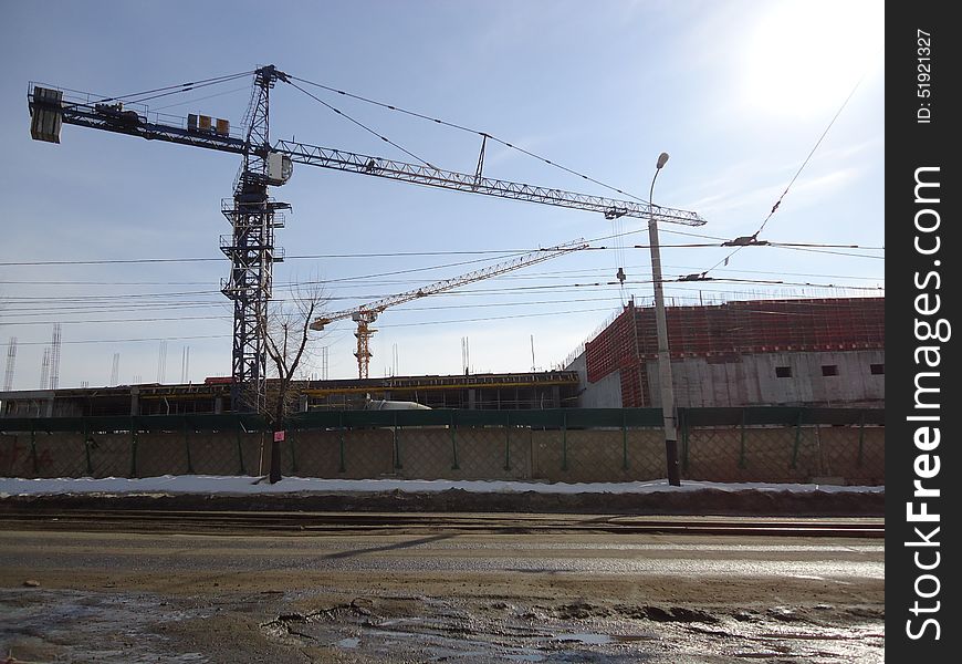 Construction crane working at a height of several tens of meters above the ground. Construction crane working at a height of several tens of meters above the ground.