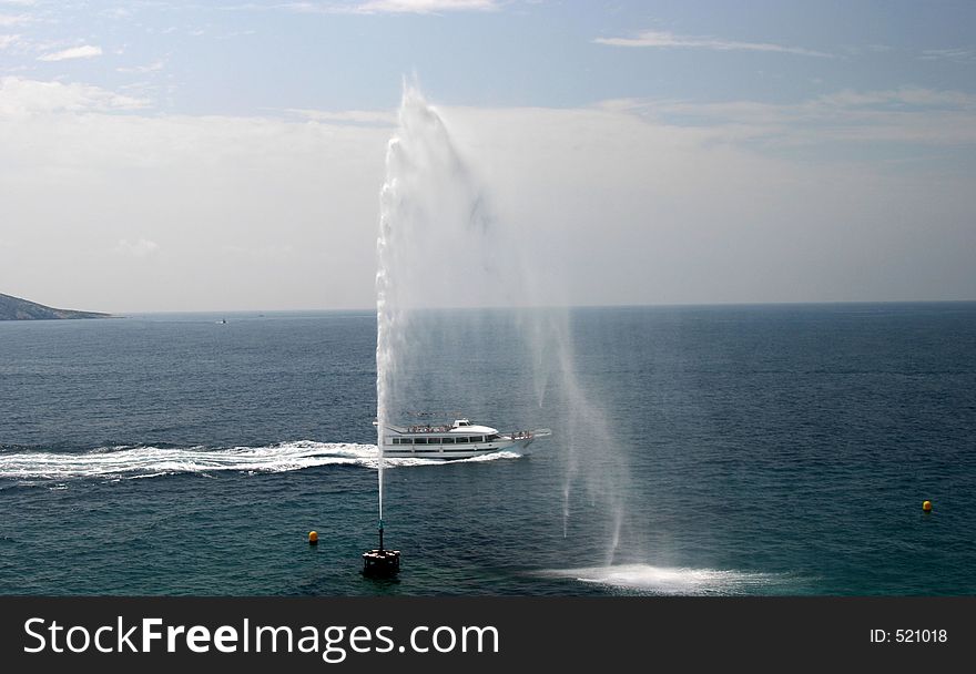 Fountain spraying water into the sea small boat passing jet. Fountain spraying water into the sea small boat passing jet