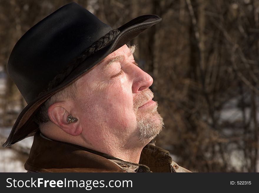 An elderly man absorbs the weak winter sun. An elderly man absorbs the weak winter sun