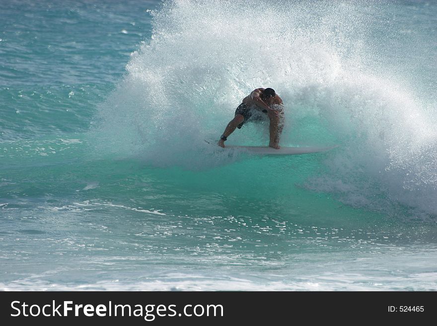 Surfer does a vicious turn on a small wave. Surfer does a vicious turn on a small wave.