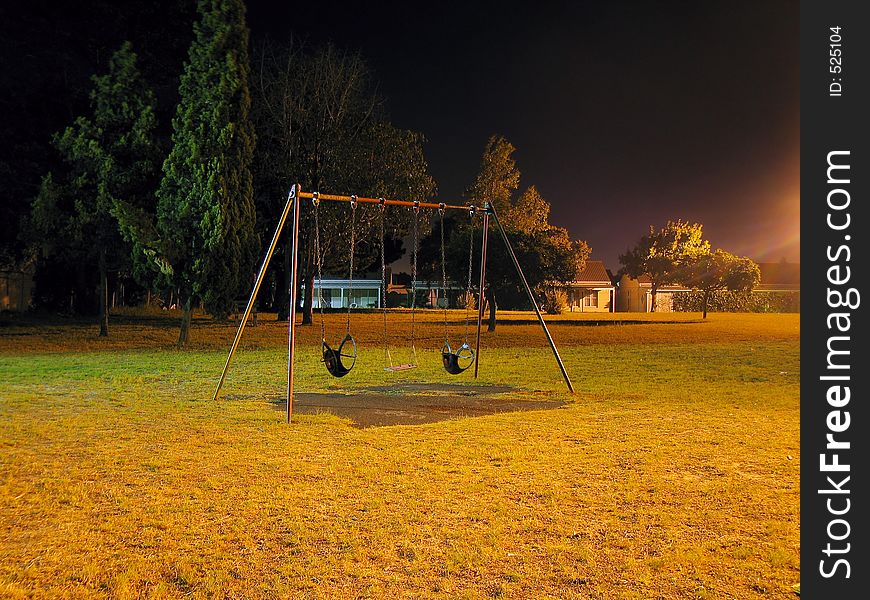 Urban park swing-set at night. Urban park swing-set at night.