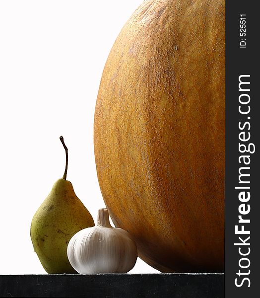 Still life with garlic pear and pumpkin on white background. Still life with garlic pear and pumpkin on white background