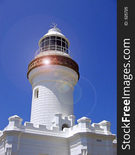 Lighthouse with lense flare to emphasise the 'light' beam.Copy space at the top in the sky. Lighthouse with lense flare to emphasise the 'light' beam.Copy space at the top in the sky.
