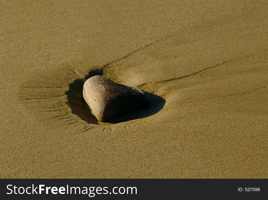 Lone Stone On Sandy Beach