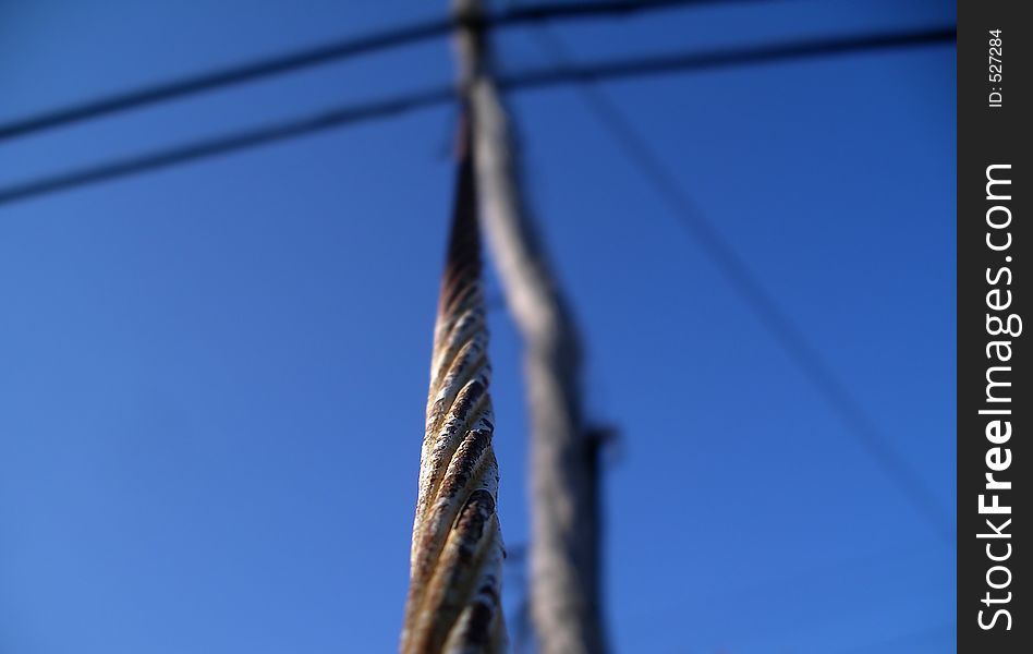Shallow field of depth. Limited focus on this power line metal pole meeting the power line at the shallow focal point. Shallow field of depth. Limited focus on this power line metal pole meeting the power line at the shallow focal point.