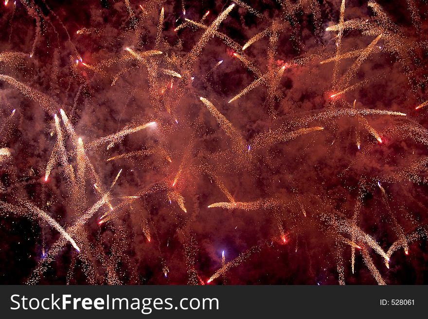 Red and white fireworks spark up the night sky. Red and white fireworks spark up the night sky.