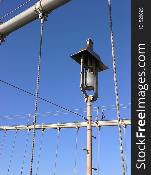 Brooklyn bridge - detail of lamp post and cables against blue sky