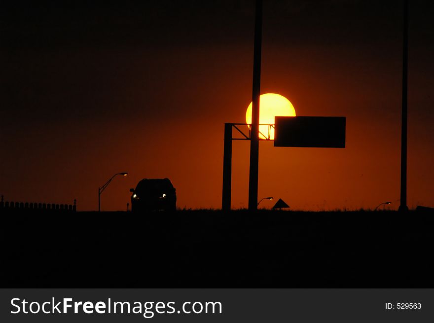 The sun goes down over the highway on a hot hazy summer day in Texas. The sun goes down over the highway on a hot hazy summer day in Texas.