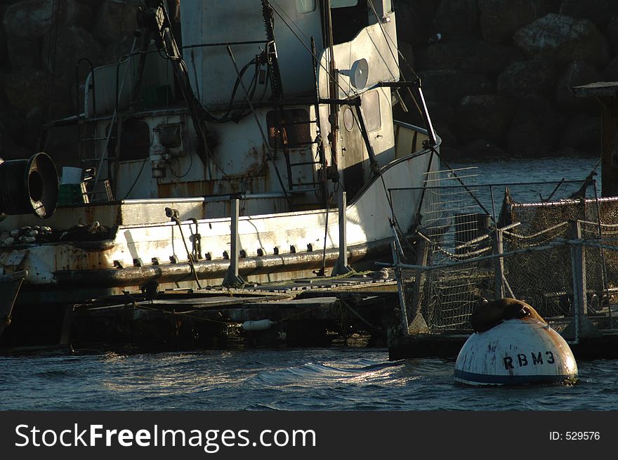 A boat sits at anchor behind the sea-wall. A boat sits at anchor behind the sea-wall.