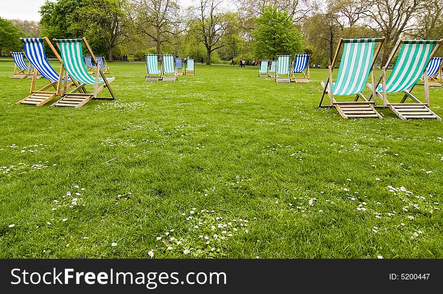 Empty deck chairs in British park.