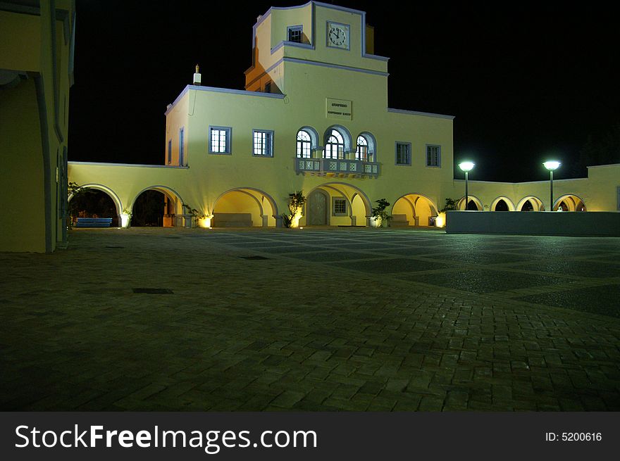 Square in front of a building that looks like the cityhall of Karpathos by night.