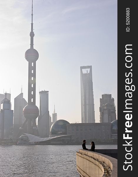 Couple talking at sunrise with Shanghai city in the background