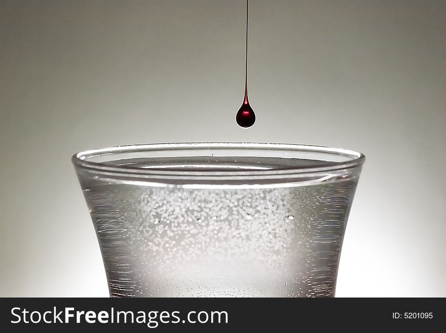 A single drop of blood into a clear class of water.  Blood may be thicker than water but there is always more water.