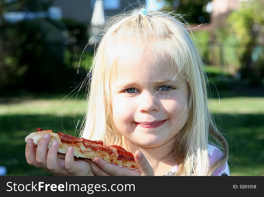 A little girl eating pizza slice