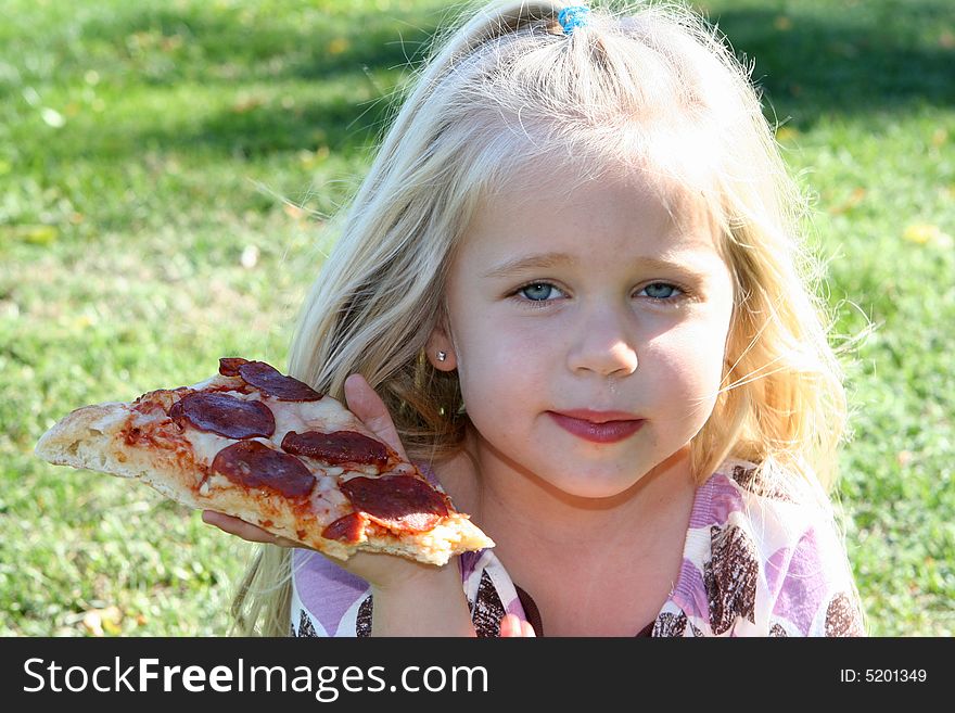 A little girl eating pizza slice