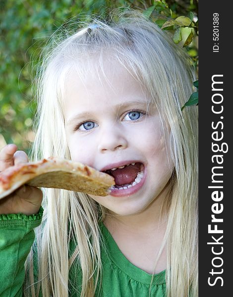 A little girl eating pizza slice