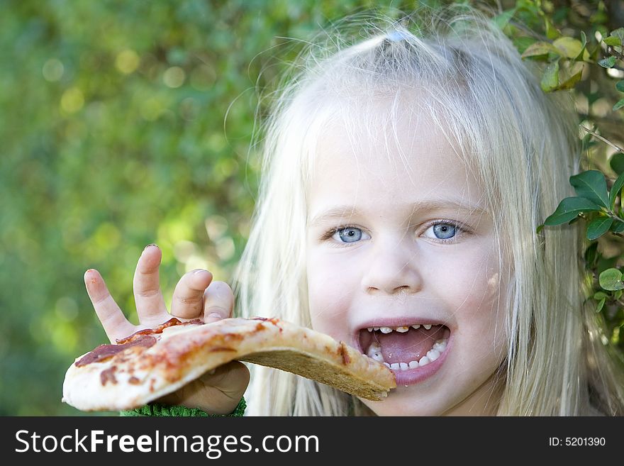 A little girl eating pizza slice