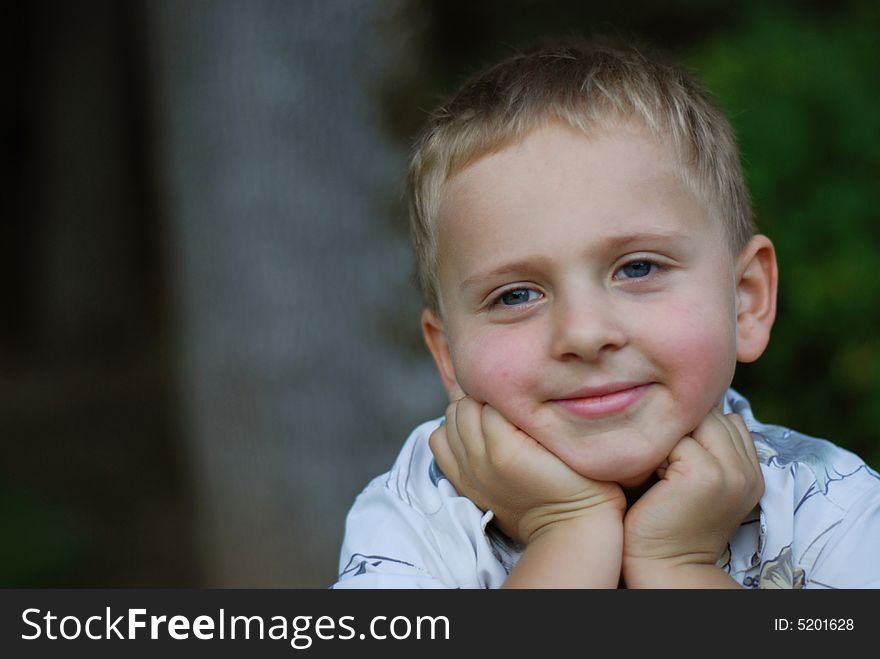 Young boy smiling and holding his head. Young boy smiling and holding his head