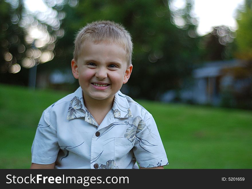 Young boy smiling and wearing Hawaiian shirt. Young boy smiling and wearing Hawaiian shirt