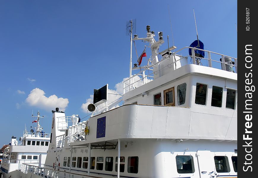 Two white passenger boats with control rooms located on the top. Two white passenger boats with control rooms located on the top.