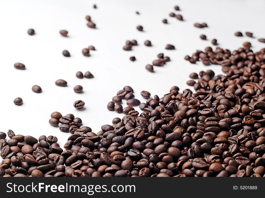 Fresh roasted coffee beans spread out on white background. Fresh roasted coffee beans spread out on white background