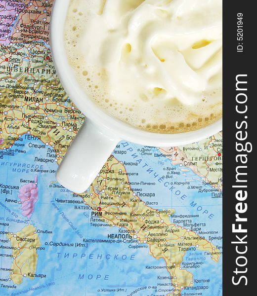 Cup of coffee with milk. Worth on the map. The map depicted Italy.