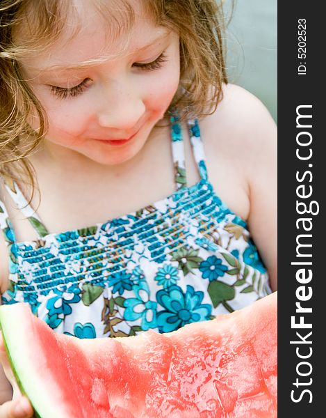 Pretty girl enjoys a tasty, huge slice of watermelon