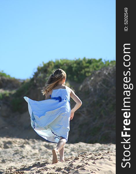 A white caucasian girl child playing on the beach. A white caucasian girl child playing on the beach