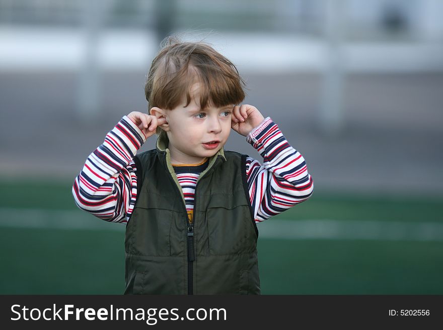 The cheerful kid on a green field of stadium