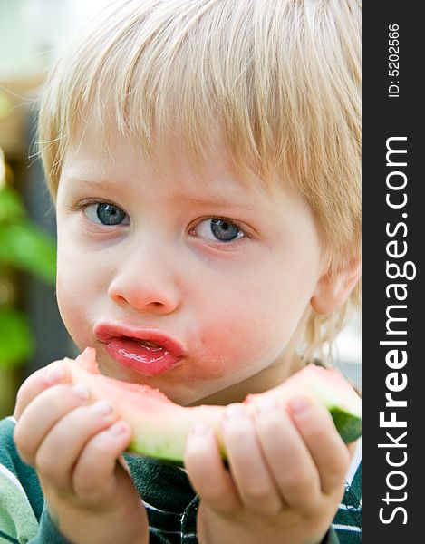 Cute boy savors the last bites of a very juicy slice of watermelon. Cute boy savors the last bites of a very juicy slice of watermelon