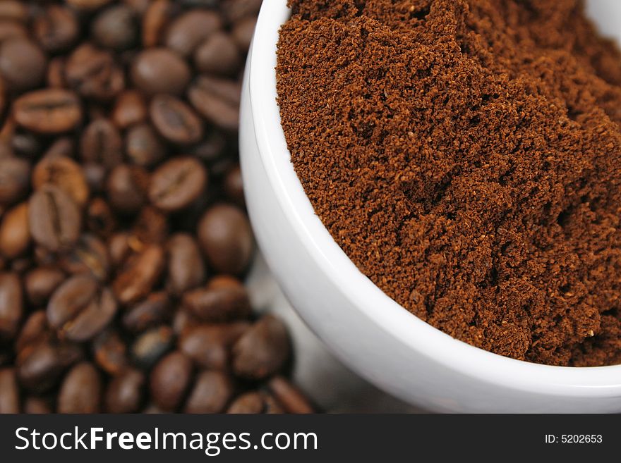 Cup of ground coffee on coffee beans background. Cup of ground coffee on coffee beans background