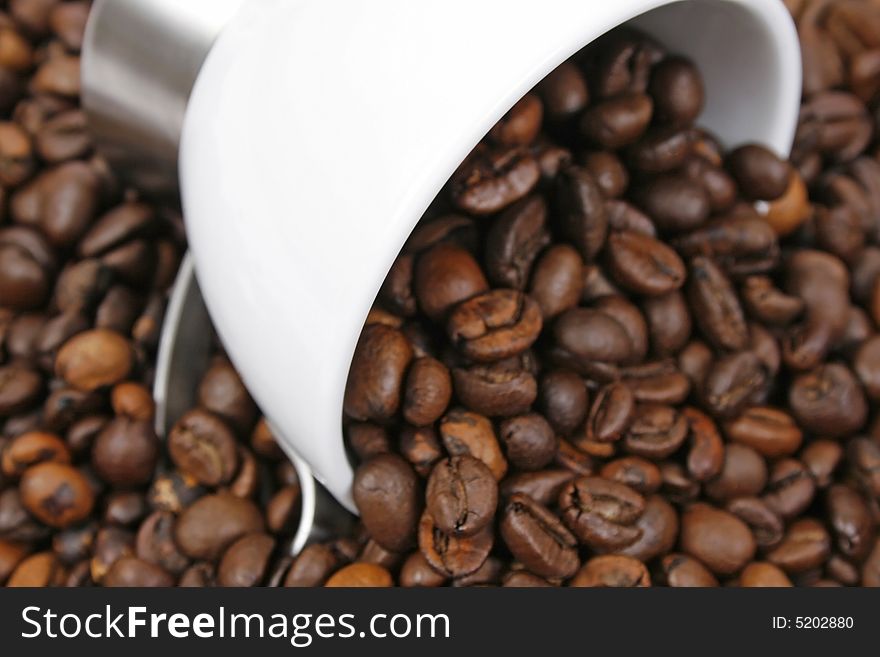 Coffee beans and white cup closeup