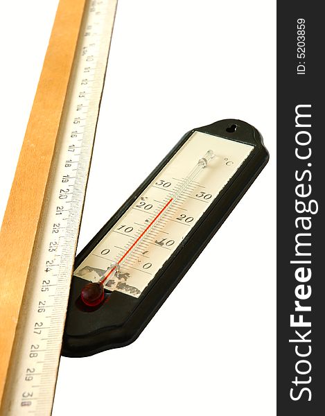 Old alcohol thermometer with Celsius scale and old wooden ruler in isolated background. Old alcohol thermometer with Celsius scale and old wooden ruler in isolated background.