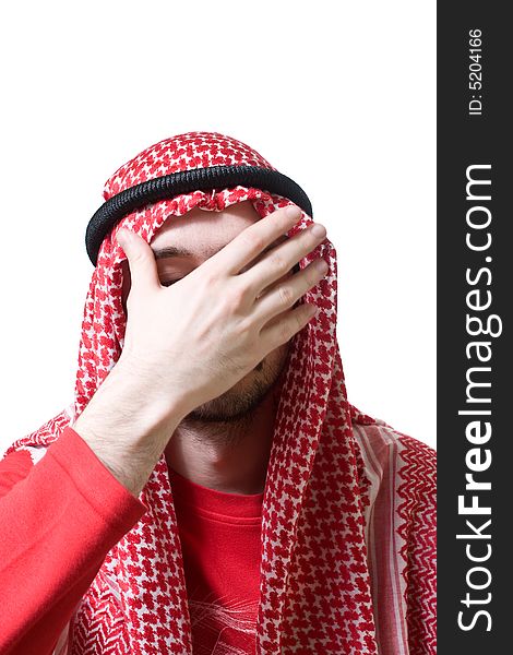 Portrait of an arabian young man in traditional headscarf - shemagh. He closed his face by hand palm.