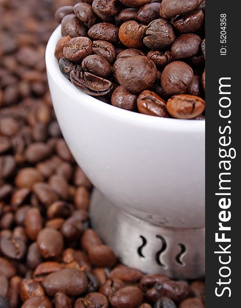 Cup of coffee beans on coffee beans background