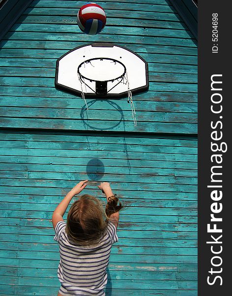 Girl trying to throw a ball in the basket. Girl trying to throw a ball in the basket